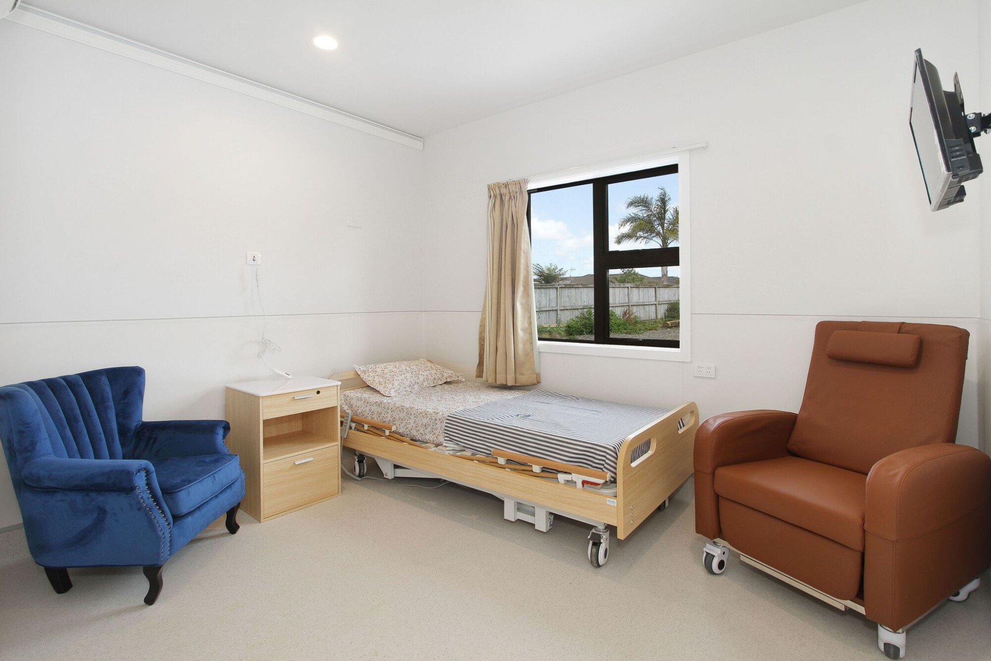 Sunlit lounge at Park Estate Home & Hospital with comfortable armchairs overlooking the garden